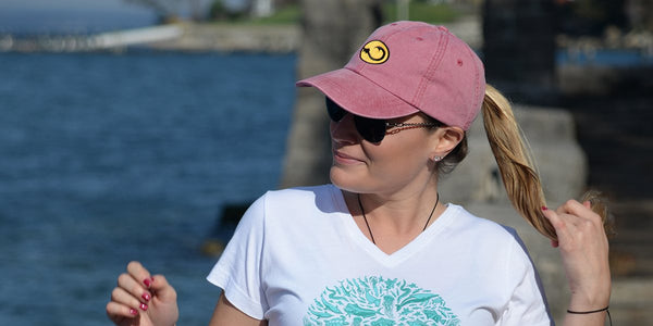 young woman wearing Hook Life fishing cap and tee shirt on a dock