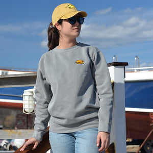 young woman in yellow fishing cap and grey sweatshirt by hook life standing on dock