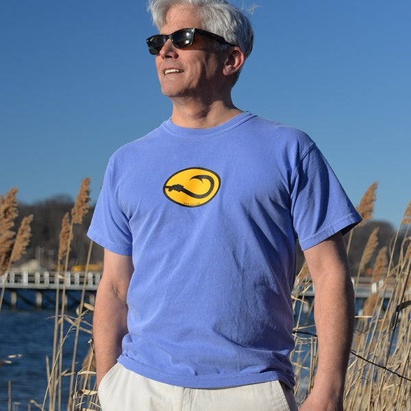 man wearing blue short sleeve Anglers Pride fishing tee shirt on a beach