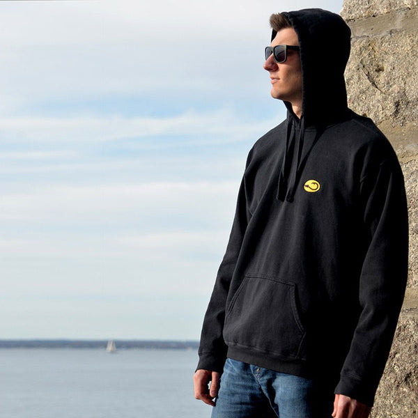 young man in black Hookie fishing hoodie sweatshirt on sea wall